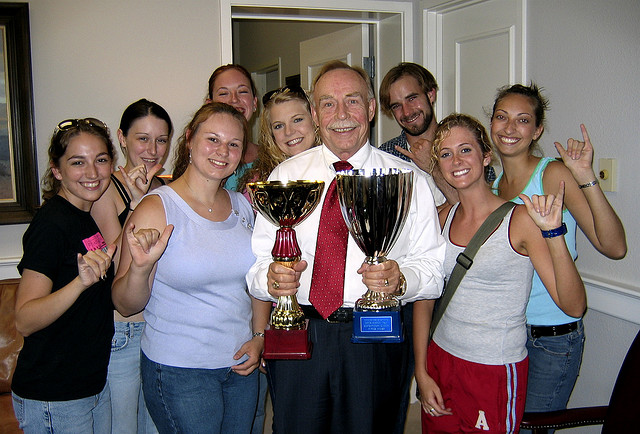 Group of dancers holding up their trophies while making the "Buffs" sign.